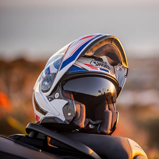 Shoei Neotec 3 Grasp balanced on a motorcycle seat with the lower part up.
