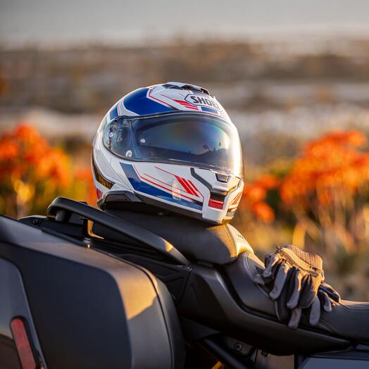 Shoei Neotec 3 Grasp perched on a motorcycle seat.